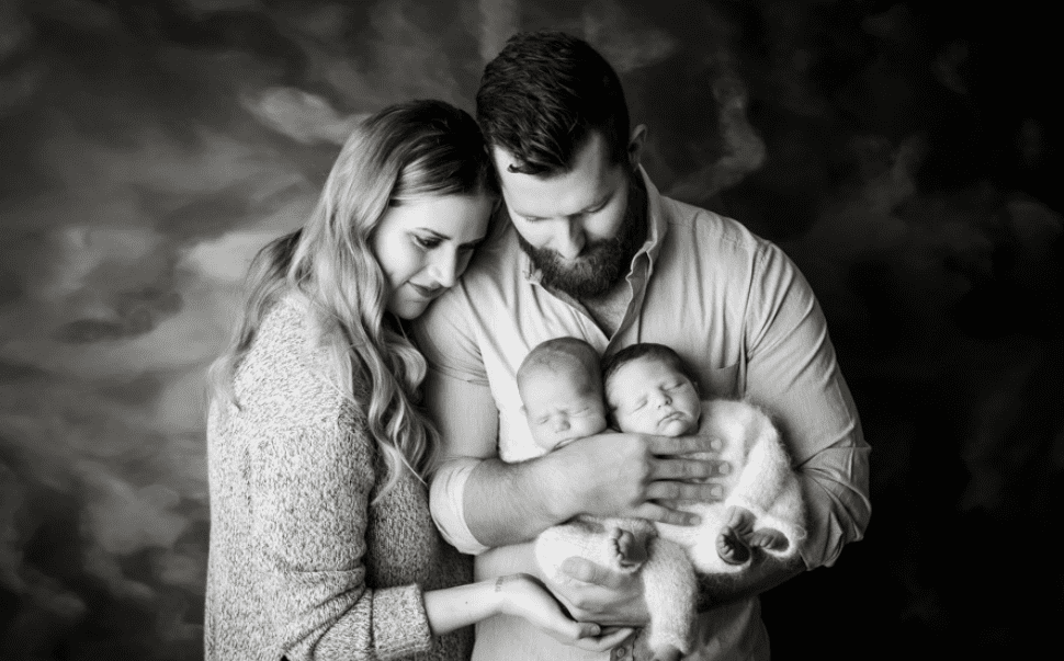 Family Photography Of A Couple Cradling Two Sleeping Infants For Family Photoshoot