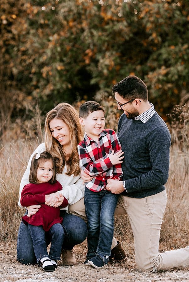 Family Of Four Smiling At Each Other For Professional Photographer In Dallas