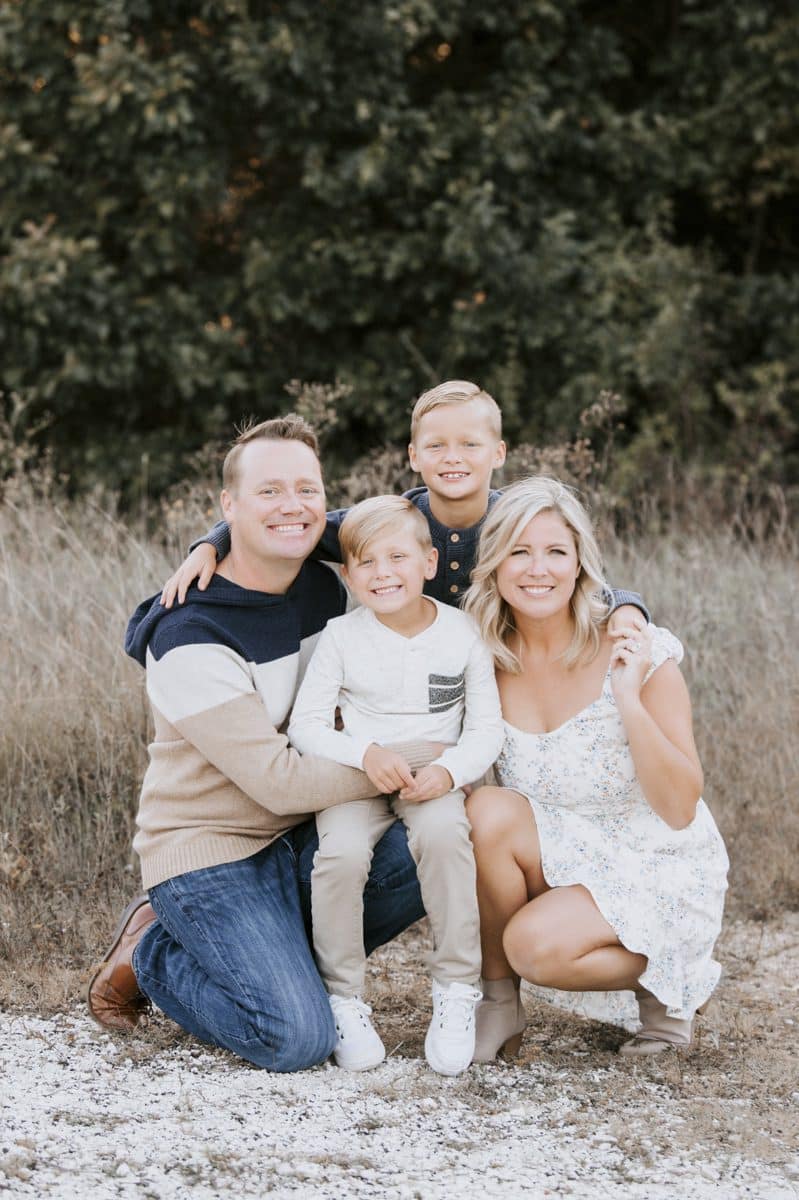 Family Of Four Smiling Posing For A Family Photo Session With Family Photographer In Dallas