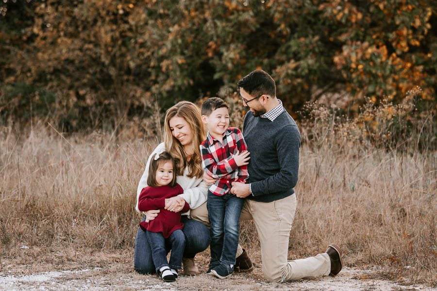 Parents holding toddler during an outdoor golden hour family photography session in Dallas